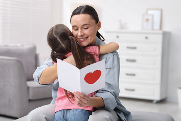 Happy Mother's Day. Little girl greeting her mom with holiday card indoors