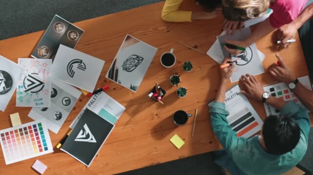 Top view of manager writing idea on sticky notes and explain idea about web design. Professional marketing team or programmer brainstorming idea while looking at tablet with color palette. Symposium.