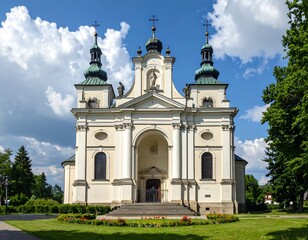 Fototapeta premium A symmetrical, cream-colored edifice with green-topped towers, intricate detail, and arched entryway stands beneath a blue sky