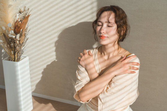 A woman doing the self-hug pose in yoga (mental care, self-esteem)