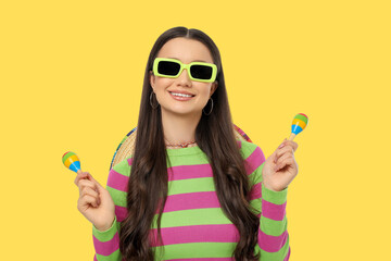 Obraz premium Cinco de Mayo, Woman with sunglasses smiles and holds maracas