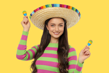 Obraz premium Cinco de Mayo, Young woman in sombrero smiles with maracas