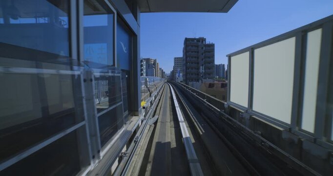 A point of view of a moving backward urban monorail at the downtown in Tokyo