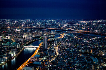 High angle aerial view of Tokyo city skyline and Sumida river at night with glowing city lights