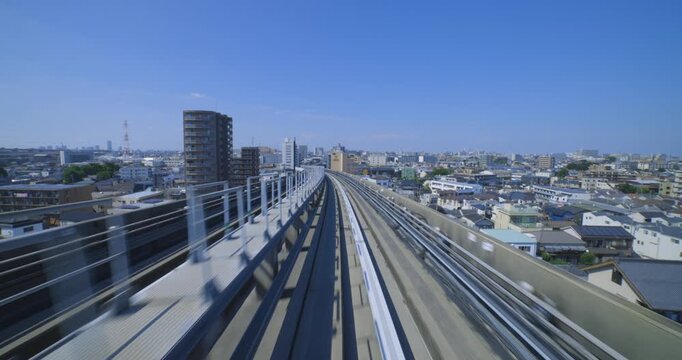 A point of view of a moving backward urban monorail at the downtown in Tokyo