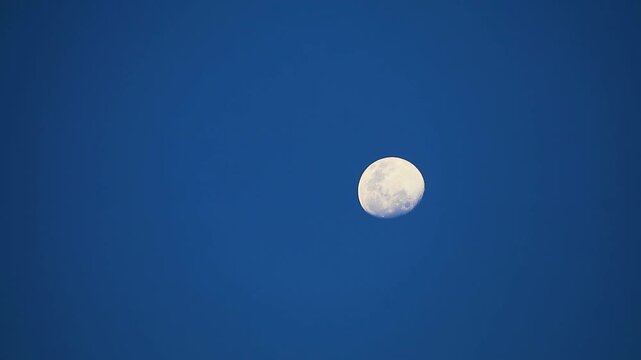 Half moon moving pass power electric line on clear night sky