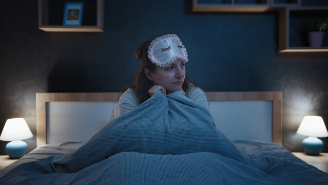 Sleepless woman sitting in bed wearing sleep mask indoors at nig, have fun and enjoy