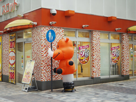 TOKYO, JAPAN - April 5, 2023: A Duo pachinko centre with an inflatable moving rhinoceros outside in Tokyo's Yurakucho area.