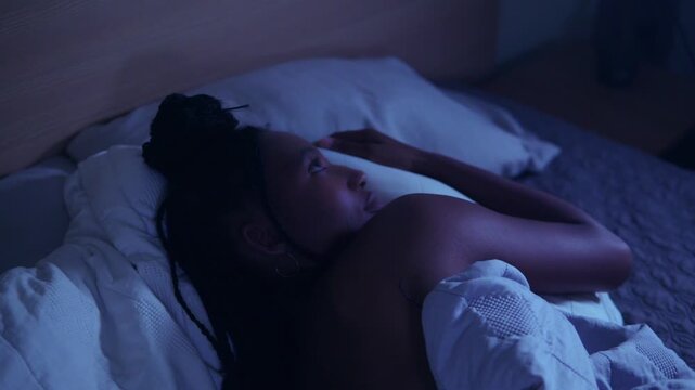 African Young Woman with restlessness lying in bed at night