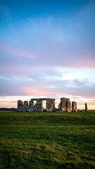 A blurred image of a prehistoric monument at sunset