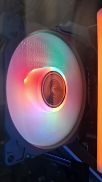 A high-quality close-up shot of a spinning PC cooling fan with vibrant green and yellow addressable RGB lighting, showcasing modern gaming hardware aesthetics.