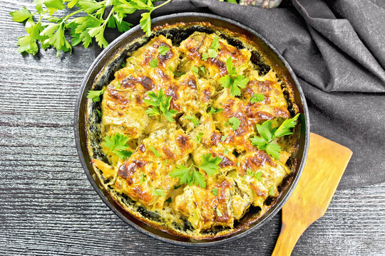 Rolls of zucchini with meat in pan on dark board top