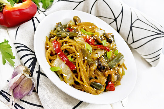 Spaghetti buckwheat with vegetables in plate on white board