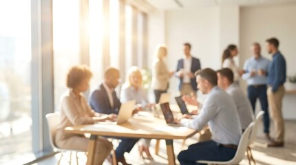 Obraz premium A bustling, blurred office environment showcases diverse professionals actively working and interacting at tables and standing near bright windows.