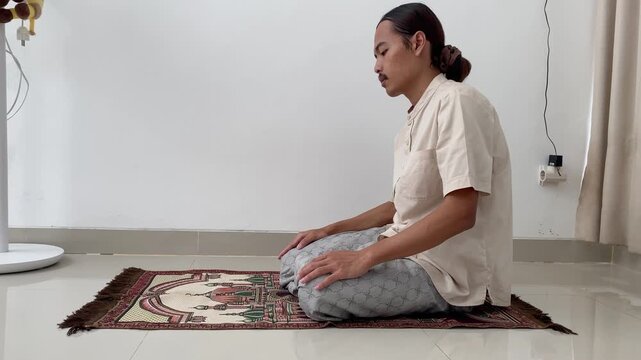 Person praying on a prayer rug during Islamic worship