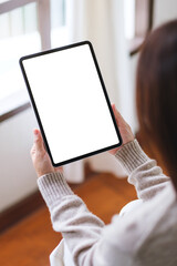 Obraz premium Vertical mockup image of a woman holding tablet with blank desktop white screen at home
