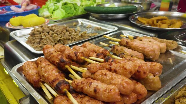 Vietnamese nem nuong street food skewers freshly grilled and displayed at a vibrant night market stall, showcasing popular asian cuisine and local tradition