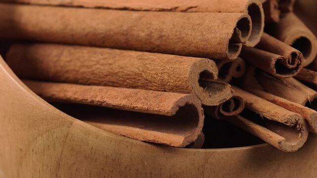 Dried cinnamon sticks in a wooden bowl