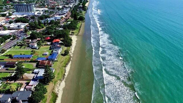 Breathtaking aerial view of  Coastal Town Suburban Houses Along a Turquoise Ocean Beach, with amazing architectures and Roads infrastructure. 