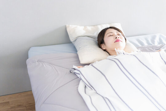 ベッドで熟睡する若い女性