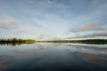 Naklejka premium Calm summer Wisconsin lake water reflecting blue sky and clouds