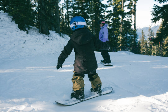 Young boy and mom snowboard together at Whistler Blackcomb