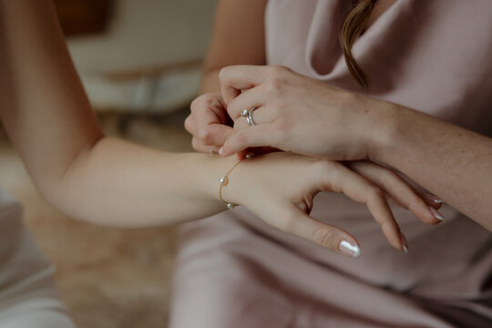 Bridesmaid helping a Bride put her Bracelet on
