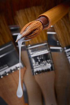 Sumi brush dripping with white paint