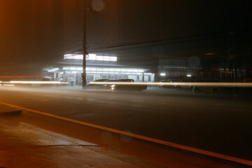 Long exposure car light trails in heavy rain at night with lone © Cavan
