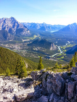 Panoramic landscape of Banff town, Bow River valley and surrounding mountains viewed from a high mountain viewpoint in Banff National Park, Alberta, Canada.