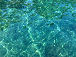 Obraz premium Crystal clear turquoise sea water with sun glare.