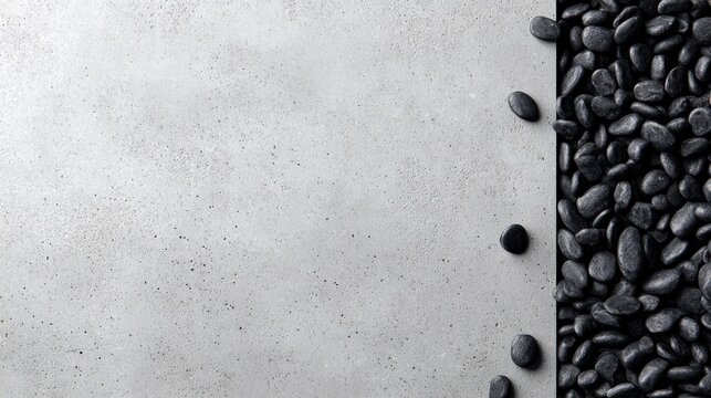 Scattered black pebbles on a grey textured background