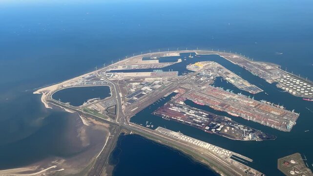aerial view over Maasvlakte Rotterdam port near North Sea coast, large harbor basins, industrial terminals and docks on reclaimed land, major maritime logistics hub supporting global shipping trade
