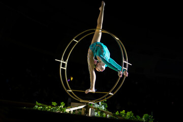 A teenage girl performs an acrobatic act on a circus ring. Concept is that children are involved in sports and circus arts © Anna