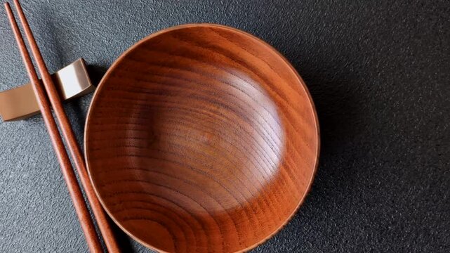 An empty round brown wooden bowl for Asian food. An empty wooden bowl as a food background for your design