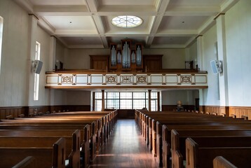 Naklejka premium A church interior with pews, an organ, and a balcony.
