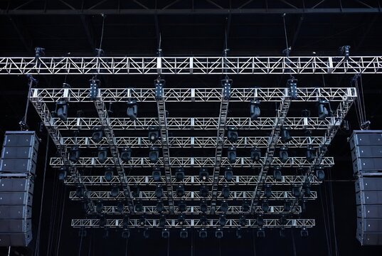 Stage lighting equipment, likely for a concert or event. It's a large indoor venue with extensive rigging and speakers.