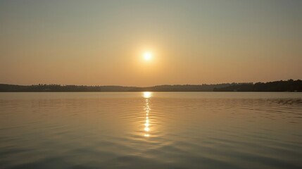 Obraz premium Golden Sunrise Reflection Over Calm Lake Water