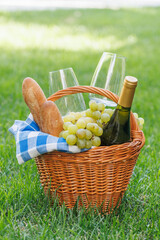 Naklejka premium Picnic basket with wine, grapes, and baguette