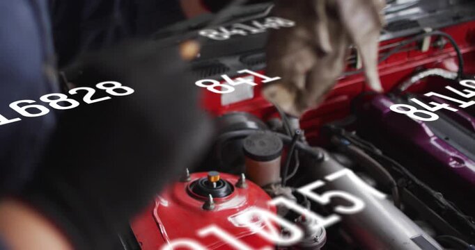 Vertical video: Auto tech reaching, wiping red strut in bay for test while white data around hands
