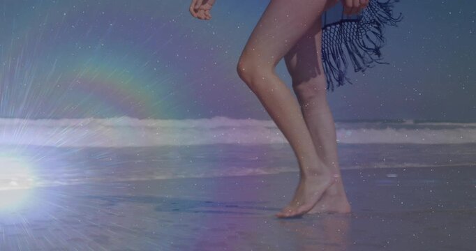 Woman stepping into frame and walking shore for marketing, halo highlighting wet sand near feet