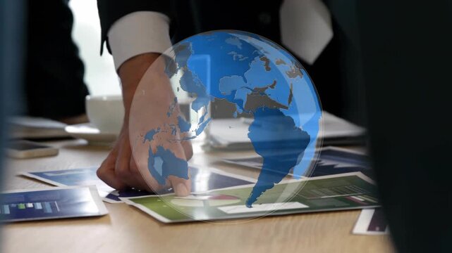 Reaching suited hand sliding brochure on meeting table left pointing reviewing under globe overlay