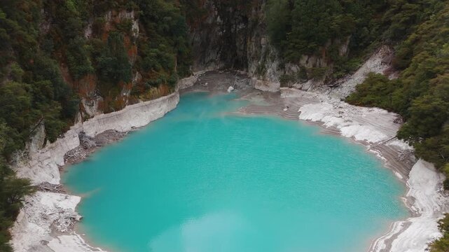 Vivid blue geothermal hot water spring in Waimangu volcanic valley, aerial