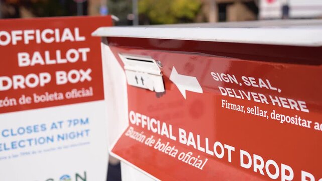 Close shot of a ballot drop box with official voting signage, showing election infrastructure, ballot submission, and civic participation.