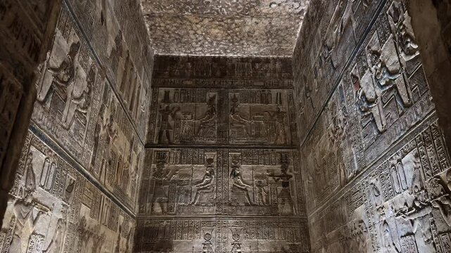 Detailed view of ancient Egyptian wall reliefs and hieroglyphics with remarkably preserved original colors and pigments inside the Temple of Hathor in Dendera
