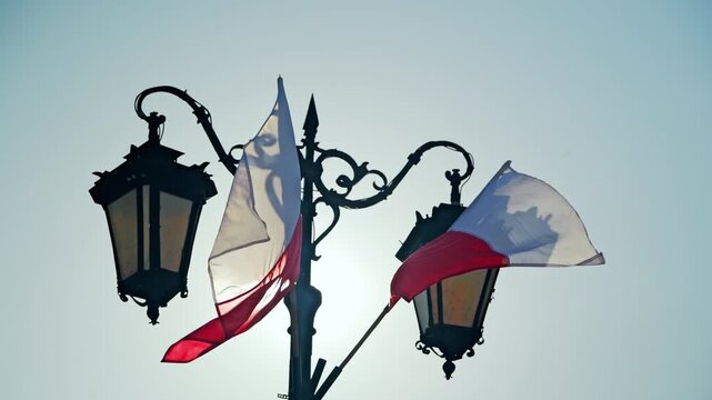 Polish national flags waving in wind beside street lamps Warsaw, Slow motion