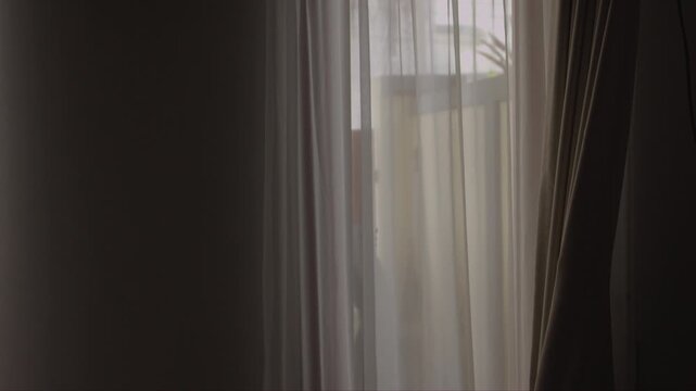 Soft natural light passes through sheer curtains, creating a calm indoor scene with a muted exterior view and a quiet home atmosphere
