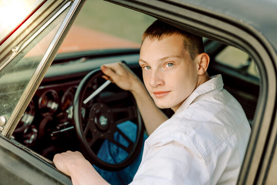 Young man driving classic vintage car