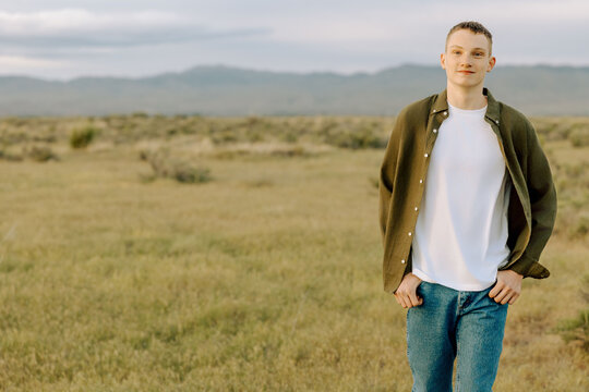 Casual young man standing in open countryside