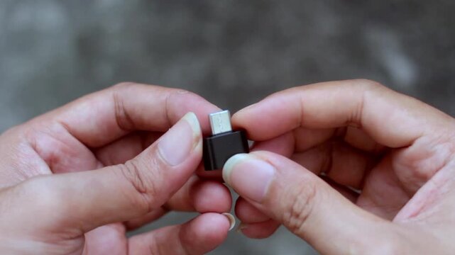 Close-up video of a hand holding a USB Type A to USB Type C adapter. Technology accessory concept showing connectivity, data transfer, and modern device compatibility.
